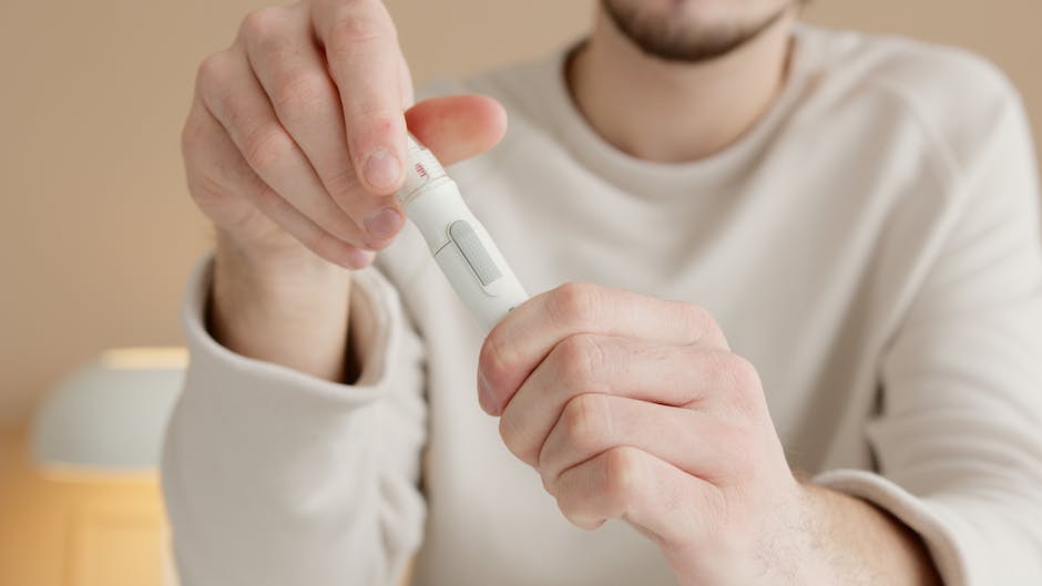 Close-up of a man checking his blood sugar levels using a glucometer indoors.