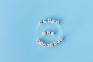Creative World Diabetes Day concept with beads on blue background.