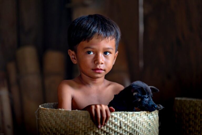 A young child sits in a basket with a puppy, showcasing innocence and companionship.