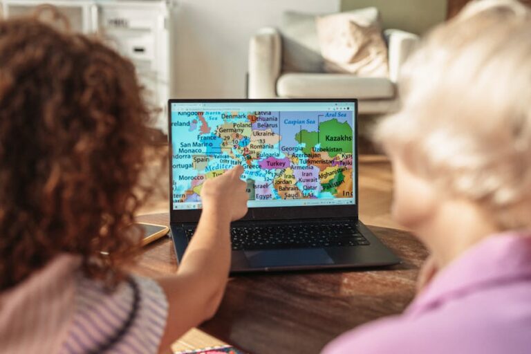 Two children pointing at a map on a laptop, symbolizing travel and exploration.