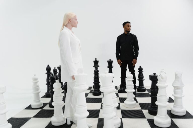 Two individuals strategize on a life-size chessboard, immersed in a game of intellect.